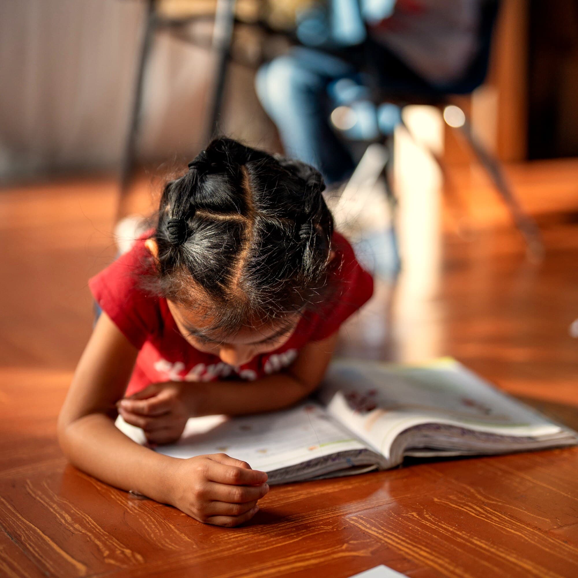 Niña concentrada leyendo en el hogar